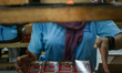 A worker packs hand-rolled kretek cigarettes in a factory in Malang, East Java, Indonesia,...