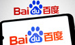 The Baidu logo appears on a smartphone screen and as the background on a laptop computer s...
