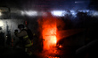 A firefighter opens a market pavilion engulfed in flames after a Russian airstrike on the...