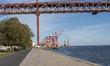 In Lisbon, Portugal, on November 22, 2025, people walk on the riverside with container cra...