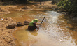 A woman collects stones from a mountain stream in an Indigenous village along the Banglade...