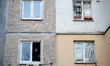 A man stands at a window of a residential high-rise damaged in a Russian combined air atta...