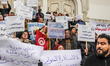 Protesters hold up signs reading in Arabic: ''the last straw, release recruitments'' while...