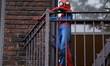 A child dresses as Spider-Man at the traditional balloon inflation for the 2025 Macy's Tha...