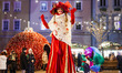 An artist in costume entertains people during the opening of the Christmas market at the c...