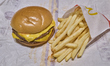 A McDonald's double cheeseburger and French fries are pictured on a tray paper inside a Mc...