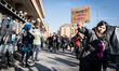 A young woman shows a banner in support of the imam Mohamed Shahin in front of the riot po...