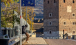A man wearing a hooded jacket sits on a metal guardrail next to a Trentino Trasporti publi...