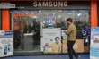 A man walks past advertisement billboards for smartphones at an electronics store in Srina...