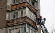 Residents of an apartment building damaged by a Russian attack are seen with a representat...