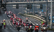 Hundreds of motorcycle drivers dressed as Santa Claus drive to the pediatric hospital to o...