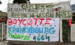 A banner is held by protesters during a demonstration by Teisseire factory workers against...