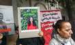 Demonstrators hold placards featuring the portrait of the detained civil society activist...