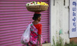 D. Saraswathy, 60, a flower vendor, walks through the road to sell flowers in Kochi, India...