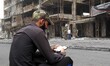 A man reads the Quran at the site of explosion in Karrada-Dakhil district in southern Bagh...