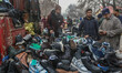 People buy footwear at the Sunday market, a weekly flea market, on a cold winter afternoon...