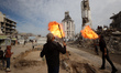 Displaced Palestinian youths perform a fire show as displaced Palestinians prepare to ushe...