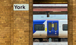 A blue and white Northern Rail Class 170 Turbostar train stops at a platform at York Railw...