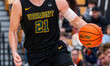 Lucas Mari (21) of the Vermont Catamounts drives the ball during an NCAA men's basketball...