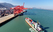 A cargo ship slowly docks at the berth for loading and unloading containers at the contain...