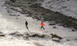 Boys run across a snow-covered field along the banks of a stream in Garmisch-Partenkirchen...