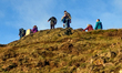 Hikers explore the rocky terrain and summit area of Arthur's Seat, an ancient extinct volc...