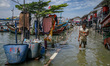 Children play in the water during tidal flooding in the Muara Angke area in Jakarta, Indon...