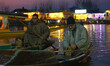 Kashmiri boatmen warm themselves with firepots (kangri) on the banks of Dal Lake on a cold...