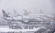 Deicing operation during heavy snow, special vehicles are removing surface frost, ice and...