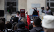 A woman holds up her fist in solidarity with the crowd during a demonstration against Immi...