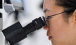 Laboratory technicians look at a plant specimen through a microscope inside the Government...