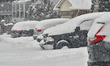 Vehicles are covered in snow as Environment Canada issues an orange level snowfall warning...