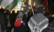 A protester with a keffiyeh and Palestine flag participates in a pro-Palestine demonstrati...