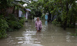 Residents walk through a road submerged by water as floods hit Bekasi City, Indonesia, on...