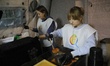 Volunteers serve free hot meals to residents at a mobile heating point operated by the Sta...