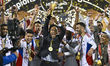 Sharjah players celebrate with the trophy on the podium after winning the Super Cup Qatar-...