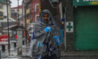 A man wrapped in warm clothes walks as it rains in Srinagar, Jammu and Kashmir, on January...