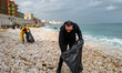 Volunteers clean up plastic and glass from the beach along the Molfetta seafront in Molfet...