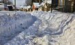 Snow covers a partially cleared sidewalk the day after a winter snowstorm hits Toronto, On...