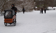 A cyclist rides through a snow-covered landscape in Faelledparken in Copenhagen, Denmark,...