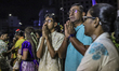 Hindu devotees gather on the street as they pray in front of Lord Muruga's silver chariot,...