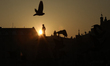 A view of the Adam Mickiewicz Monument on the Main Market Square at sunset is seen in Krak...