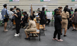A voter casts a ballot as people queue up during advanced voting in Bangkok, Thailand, on...