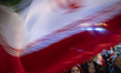 A young Iranian woman waves a national flag while participating in a state-run religious f...