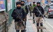 Indian security personnel patrol along a road during a random security check in Srinagar,...