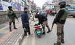 Indian security personnel frisk a motorcyclist during a random security check in Srinagar,...