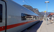 A white Deutsche Bahn ICE high-speed train stands at the platform with the snow-covered Ba...