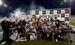 Hibernians players and staff members celebrate with the BOV Super Cup trophy after the Mal...