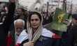 An Iranian woman carries a sign of the Islamic Revolutionary Guard Corps (IRGC) and partic...