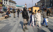 Indian tourists pass by as an Indian security personnel stands guard during a precautionar...